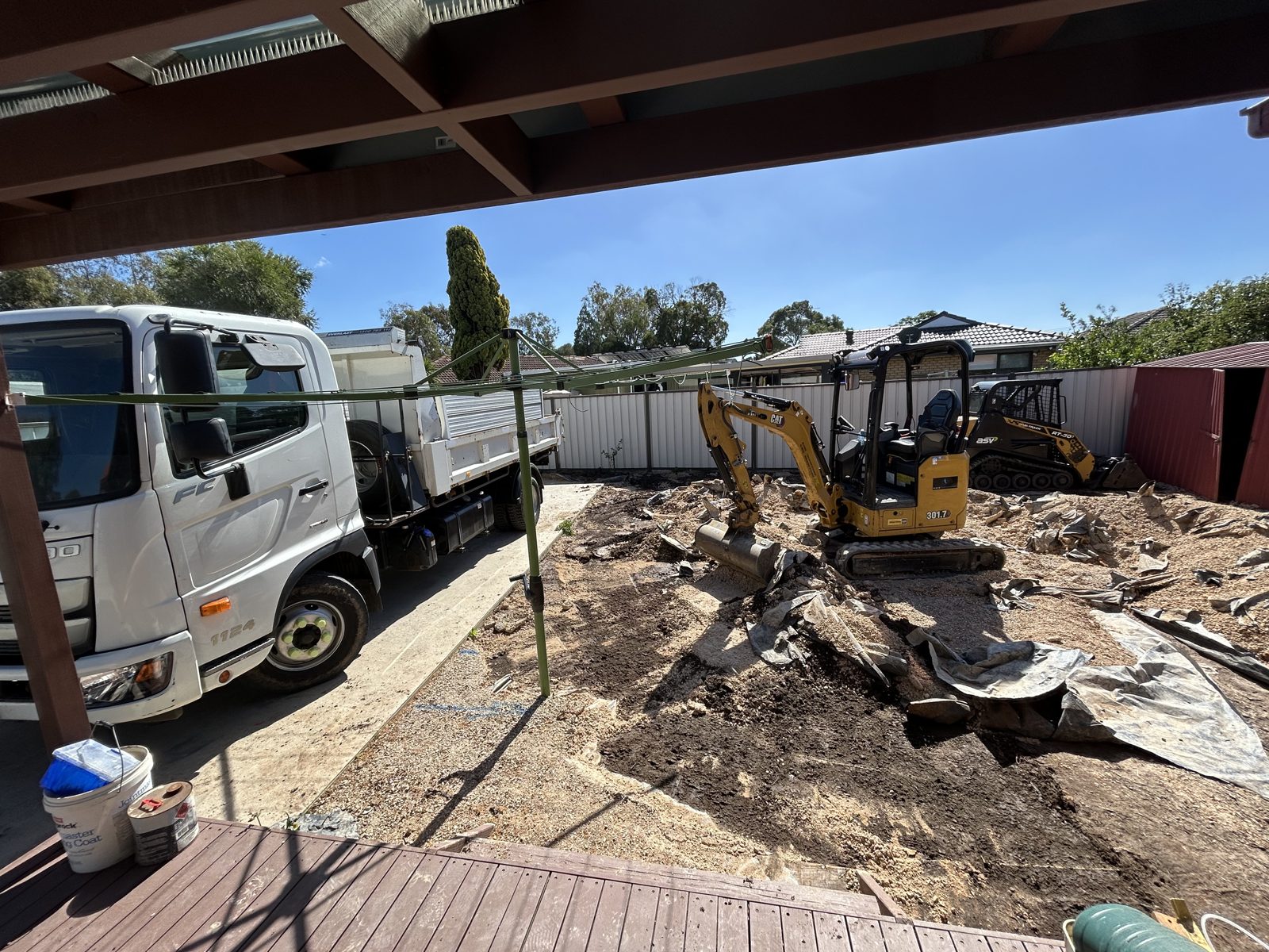 Rigid Earthworks excavator and Posi-Track breaking out concrete beside a loaded tipper truck in St Albans